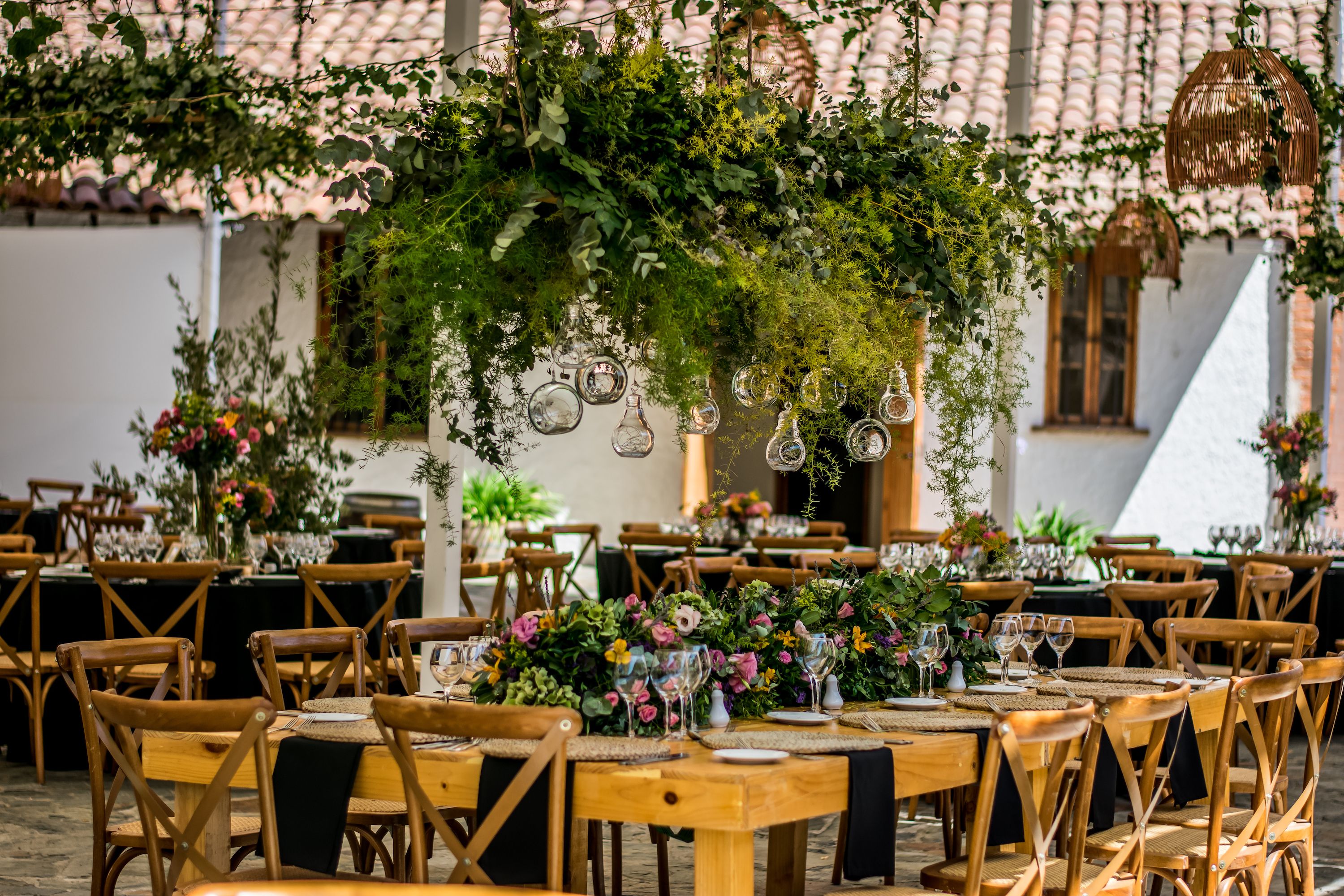 Recepción en patio con follaje colgante y mesas montadas